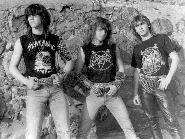 Metalowcy — trzej nastoletni fani thrash metalu w koszulkach Slayer i pasach z nabojami, lata 80.